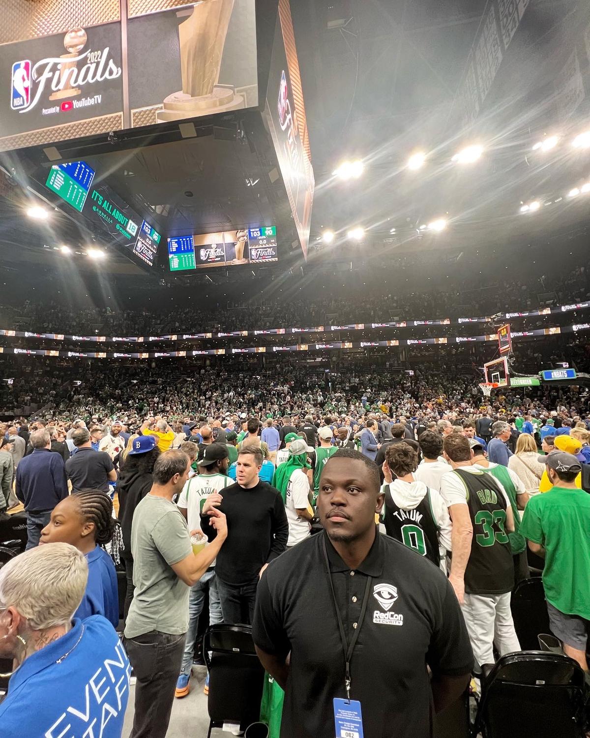 Uniformed Redcon security guard monitoring a crowded arena